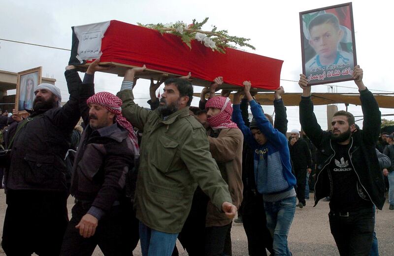In this photo released by the Syrian official news agency SANA, mourners carry the coffin of Rafat Nashat during a mass funerals in Sweida province, Syria, Saturday, Nov. 10, 2018.  Nashat was kidnapped by Islamic State militants with nearly two dozen others in July from the southern Sweida province during a bloody attack on their villages.  (SANA via AP)