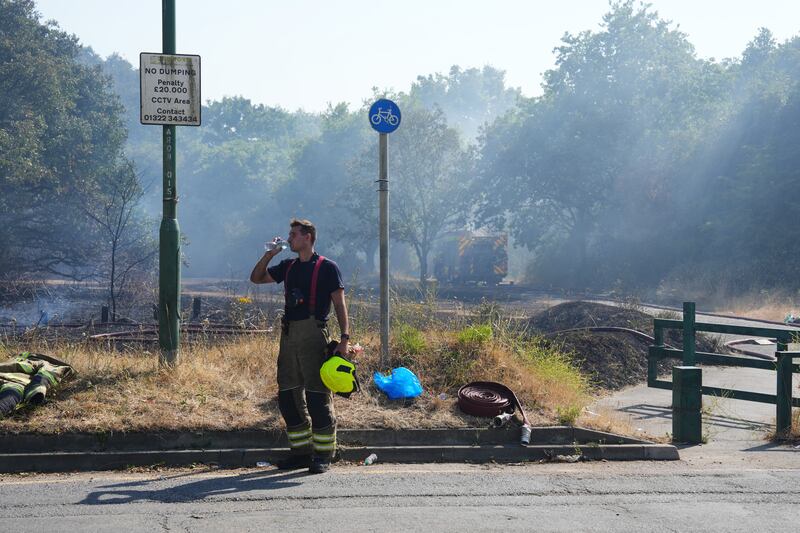 A firefighter has a drink of water after the major blaze on Dartford Heath. Getty