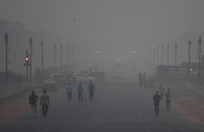 (FILES) In this file photo taken on November 2, 2018 Indian pedestrians walk amid heavy smog conditions in New Delhi. Residents of the Indian capital New Delhi lose on average ten years off their life expectancy due to the catastrophic effect of the city's air pollution, compared to their expected life longevity if they were breathing healthy air, according to a study published by the University of Chicago on November 19. / AFP / Money SHARMA

