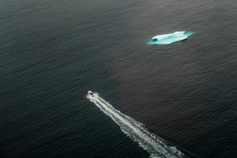 A small skiff motor past an iceberg in the open ocean near Tasiilaq, Greenland, June 24, 2018. REUTERS/Lucas Jackson  SEARCH "JACKSON TASIILAQ" FOR THIS STORY. SEARCH "WIDER IMAGE" FOR ALL STORIES.