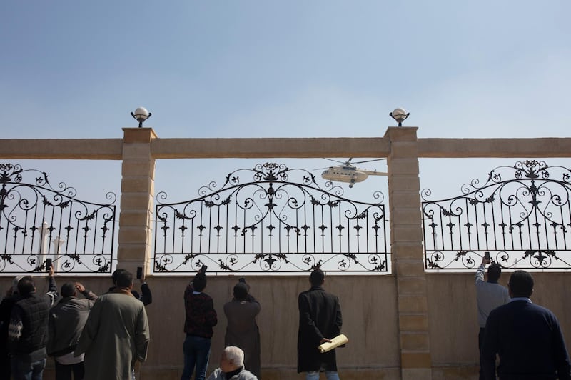 Supporters of ousted President Hosni Mubarak film a helicopter bringing the body of former President Hosni Mubarak before his funeral. AP Photo