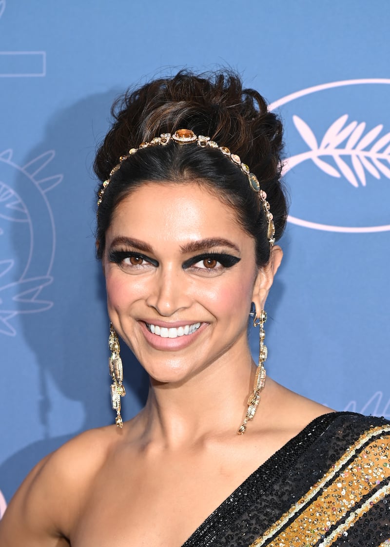 The actress' look was completed with bold black eye make-up, a gold headband and chandelier earrings. Getty Images 