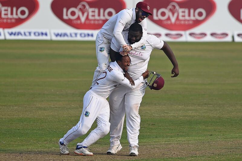 West Indies' John Campbell, top, with teammates Rahkeem Cornwall, right, and Shayne Moseley celebrate the dismissal of Bangladesh's Liton Das during the fourth day of the second Test at the Sher-e-Bangla National Stadium in Dhaka on Sunday, February 14, 2021. AFP