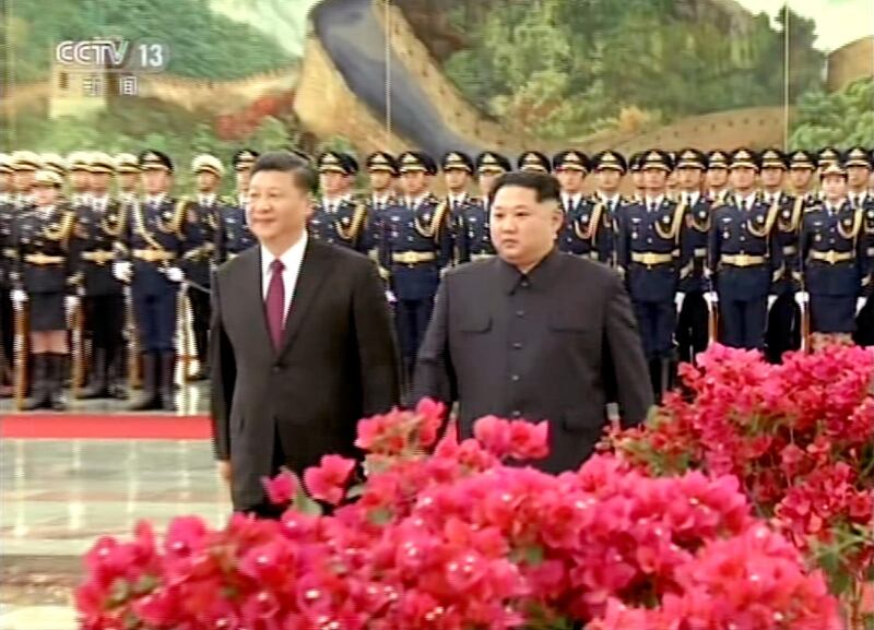 North Korean leader Kim Jong Un, right, and Chinese counterpart Xi Jinping, left, attend a welcome ceremony in Beijing. CCTV via AP Video