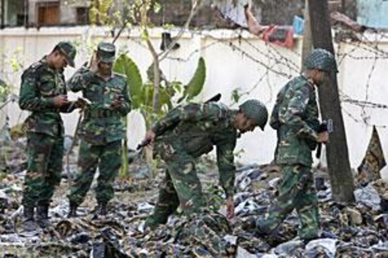 Army soldiers inspect the abandoned uniforms of the rebel Bangladesh Rifles members inside the BDR headquarters in Dhaka yesterday.