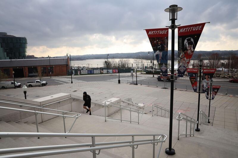 A lone person exercises outside Nationals Park, home to the World Series Champion Washington Nationals, as the stadium sits empty on the scheduled date for Opening Day March 26, 2020 in Washington, DC. AFP