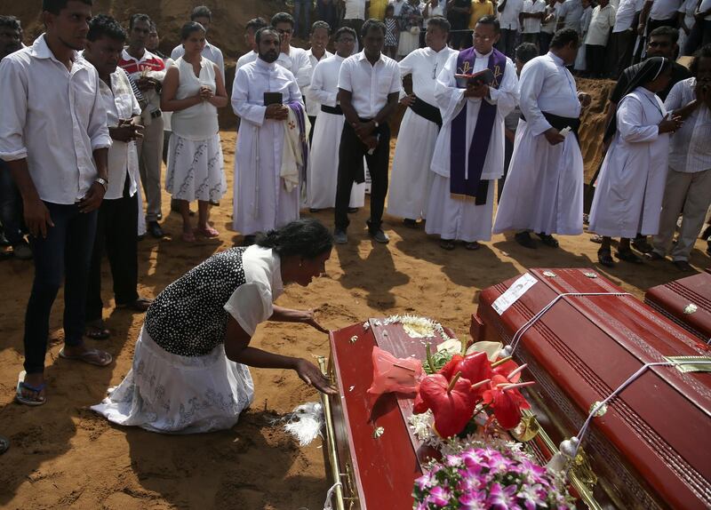 A woman reacts next to a coffin of a relative. Reuters