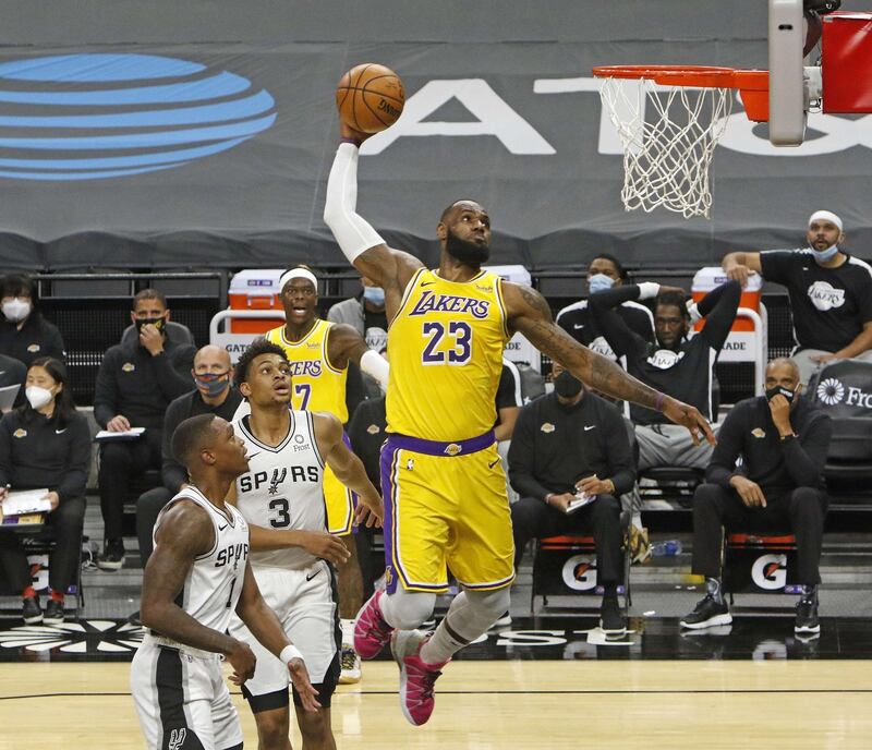 SAN ANTONIO, TX - DECEMBER 30 LeBron James #23 of the Los Angeles Lakers dunks past spurs defenders during first half action at AT&T Center on December 30, 2020 in San Antonio, Texas. NOTE TO USER: User expressly acknowledges and agrees that , by downloading and or using this photograph, User is consenting to the terms and conditions of the Getty Images License Agreement.   Ronald Cortes/Getty Images/AFP
== FOR NEWSPAPERS, INTERNET, TELCOS & TELEVISION USE ONLY ==
