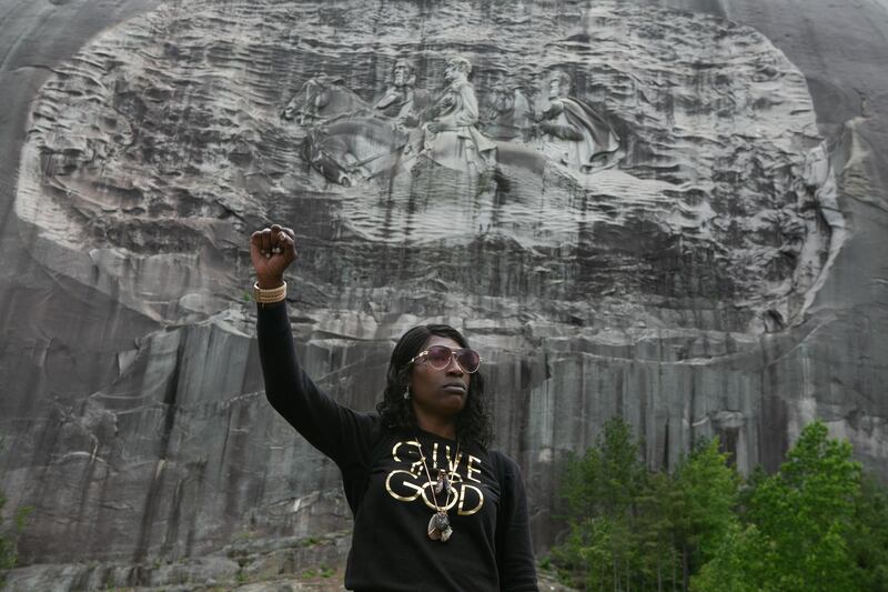 Lahahuia Hanks holds up a fist in front of the Confederate carving at Stone Mountain Park during a Black Lives Matter protest in Stone Mountain, Georgia. Getty Images