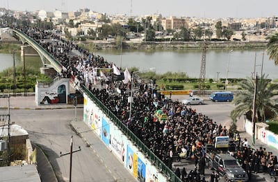 Iraqi Shiite pilgrims carrying a mock coffin or their shoulders to mark the anniversary of the death of Imam Moussa al-Kadhim, defy a curfew imposed by the authorities to prevent the spread of novel coronavirus COVID-19, in Iraq's southern city of Nasiriyah in Dhi Qar province, on March 21, 2020.    / AFP / Asaad NIAZI
