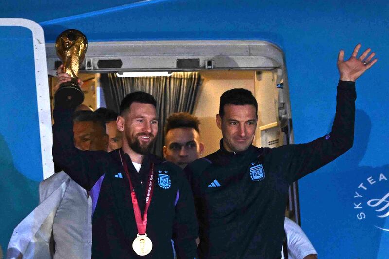 Argentina manager Lionel Scaloni and Lionel Messi with the World Cup trophy after arriving at Ezeiza International Airport. AFP
