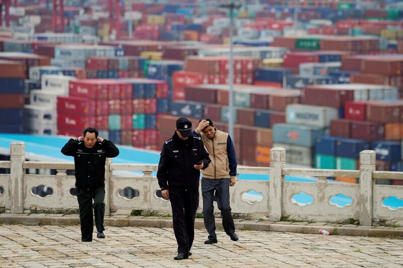 FILE PHOTO: Security guards walk in front of containers at the Yangshan Deep Water Port in Shanghai, China April 24, 2018. REUTERS/Aly Song/File Photo