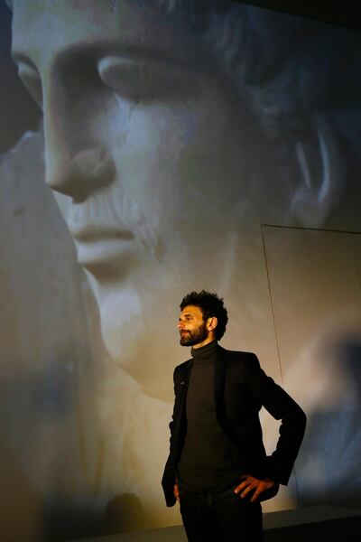 French researcher Yves Ubelmann looks on in the Palmyra Exhibit, a three-dimensional projection featuring never-before-seen images of Palmyra taken by a drone in April after the city was liberated from IS fighters, at Grand Palais in Paris, Tuesday, Dec.13, 2016. As Islamic State extremists recapture the ancient Syrian city of Palmyra, the French president and the UNESCO chief are inaugurating an exhibit in Paris to educate the public about the wonders of endangered UNESCO heritage sites in Palmyra and the Middle East. (AP Photo/Francois Mori)