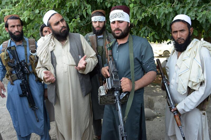 (FILES) In this file photo taken on June 16, 2018, Afghan Taliban militants stand with a resident as they celebrate the ceasefire on the second day of Eid in the outskirts of Jalalabad. Extraordinary scenes of Afghan Taliban and security forces spontaneously celebrating a historic ceasefire showed many fighters on both sides were fed up with the conflict, raising hopes that peace in the war-torn country was possible, analysts said.  - TO GO WITH Afghanistan-unrest-ceasefire,FOCUS by Allison Jackson
 / AFP / NOORULLAH SHIRZADA / TO GO WITH Afghanistan-unrest-ceasefire,FOCUS by Allison Jackson
