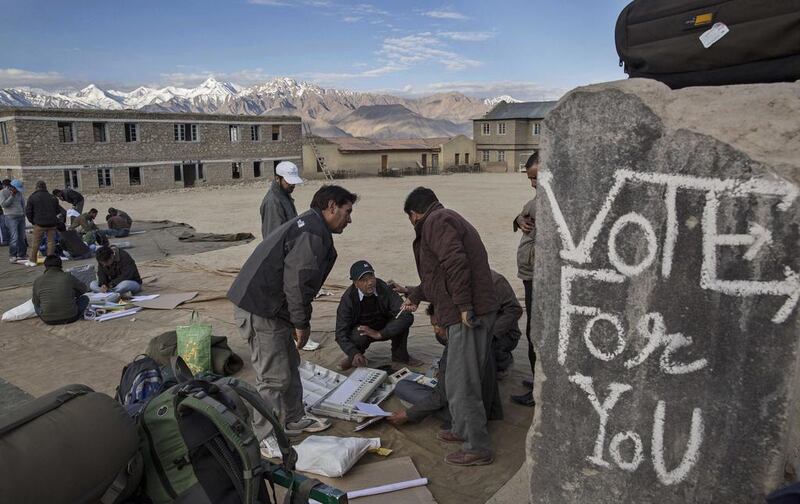 Election workers check voting machines before leaving a central collection point for polling stations.