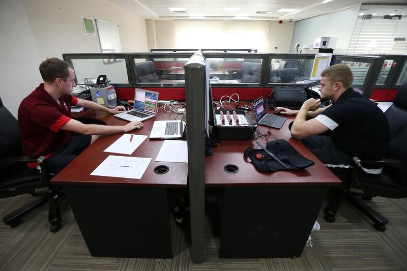 Chris Loxton, head of performance analysis at Al Ahli, on the left, and Michael Lawson, a sports scientist with the club on the right, at work in the Al Ahli offices at the Rashid Stadium in Dubai. Pawan Singh / The National