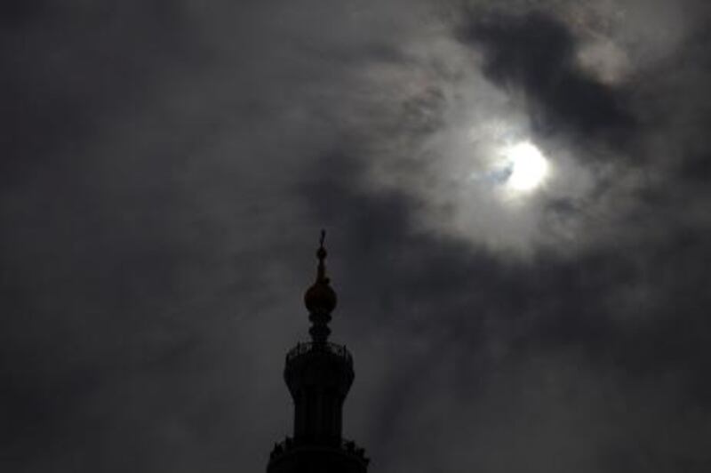 January 4 2010, Abu Dhabi, UAE: 

One of Sheik Zayed Mosque's minarets looms in the foreground as a partial lunar eclipse occurs over Abu Dhabi. Visibility was low due to an uncharacteristically cloudy day.

Lee Hoagland/The National