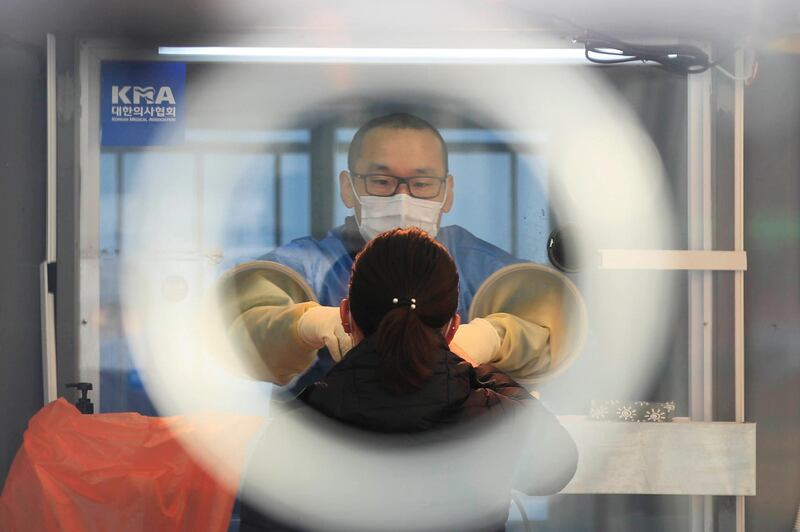 A medical worker prepares to take samples at a coronavirus testing site in Seoul, South Korea. Newsis via AP