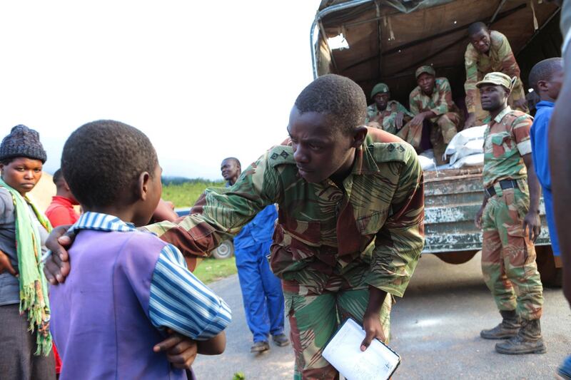 A soldier attends to a child while distributing food supplies in Chimanimani, about 600km southeast of Harare, Zimbabwe. AP Photo
