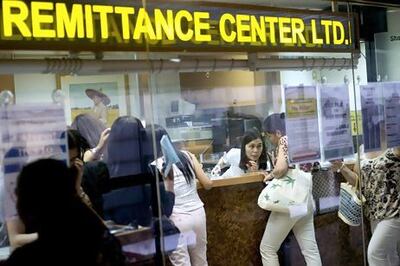 Transactions are made at a remittance agent who specialises in Philippine peso transactions in Hong Kong. Nelson Ching / Bloomberg News