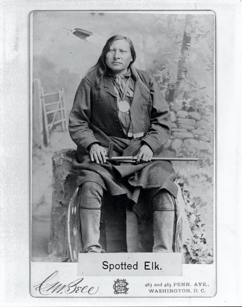 A portrait of Spotted Elk, a North American Indian man, wearing a feather headdress and holding a peace pipe on his lap.   (Photo by C.M. Bell Photography/Library of Congress/Corbis/VCG via Getty Images)