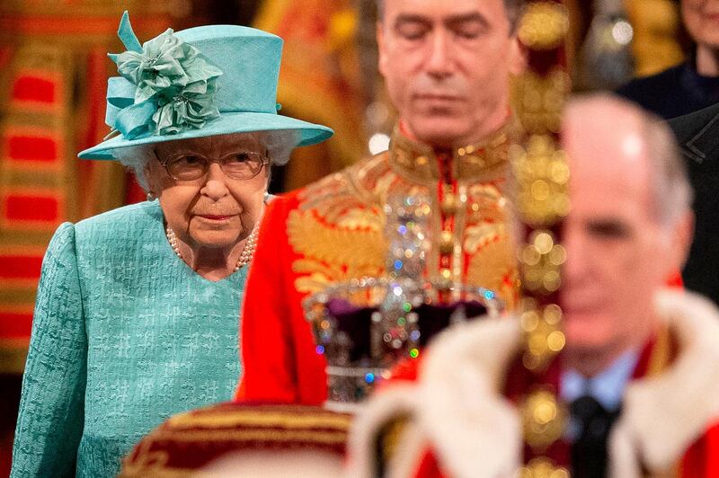 TOPSHOT - Britain's Queen Elizabeth II walks behind the Imperial State Crown as they proccess through the Royal Gallery, before the Queen's Speech, during the State Opening of Parliament at the Houses of Parliament in London on December 19, 2019. The State Opening of Parliament is where Queen Elizabeth II performs her ceremonial duty of informing parliament about the government's agenda for the coming year in a Queen's Speech. / AFP / POOL / Matt Dunham
