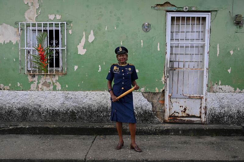 A woman wearing a vintage police uniform poses for a picture during the celebration of Holy Innocents Day in Caucagua, Venezuela. AFP