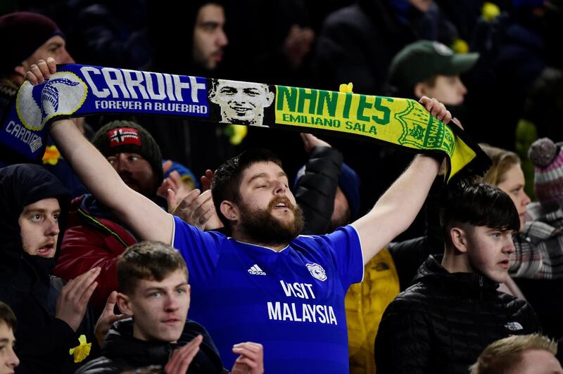 A Cardiff City fan holds up a scarf paying tribute to Sala during the match. Reuters