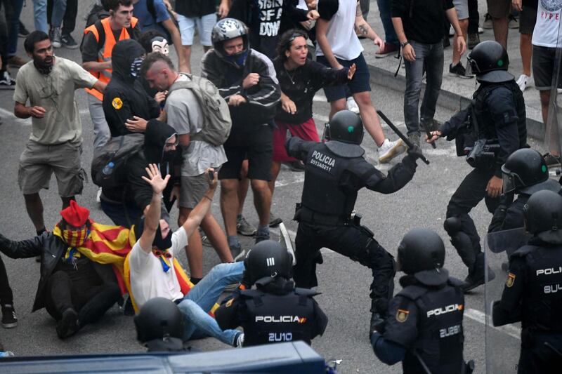 Protesters clash with Spanish policemen outside El Prat airport in Barcelona on October 14, 2019 as thousands of angry protesters took to the streets after Spain's Supreme Court sentenced nine Catalan separatist leaders to between nine and 13 years in jail for sedition over the failed 2017 independence bid.  As the news broke, demonstrators turned out en masse, blocking streets in Barcelona and elsewhere as police braced for what activists said would be a mass response of civil disobedience. / AFP / LLUIS GENE
