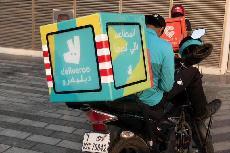 PNEXM7 Deliveroo drivers on mopeds in Dubai, UAE. Alamy
