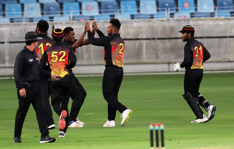 Norman Vanua of Papua New Guinea (No 2) celebrates after taking the wicket of Oman's Ayaan Khan.