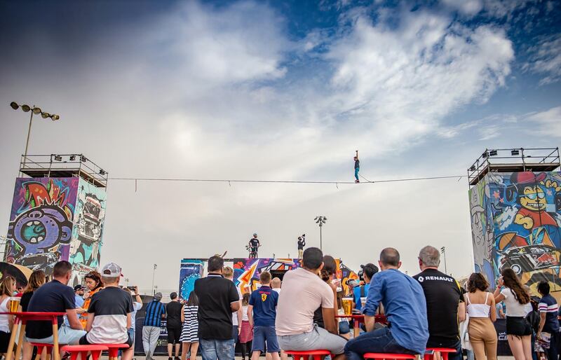 A crowd watches a tightrope walker.