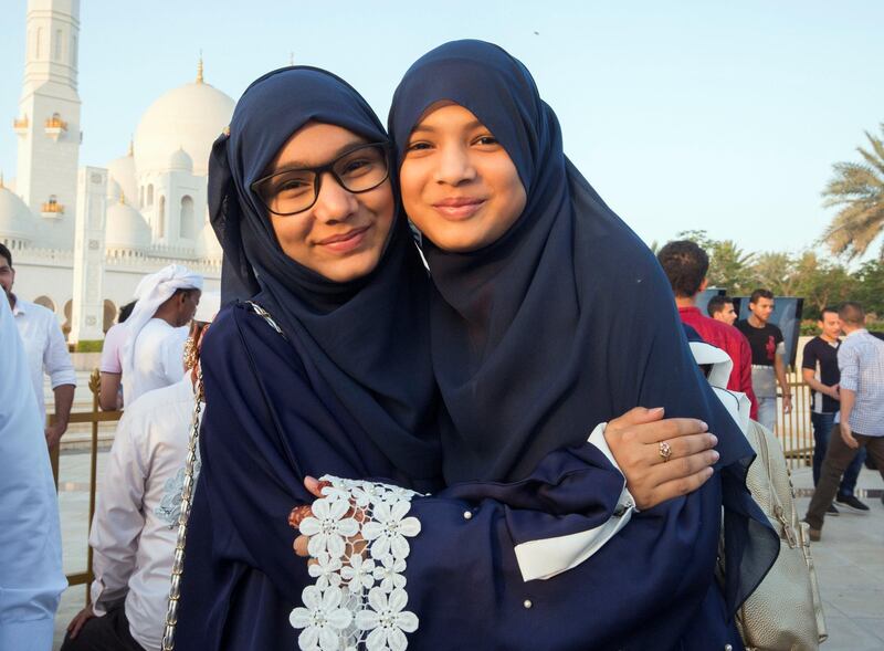 Abu Dhabi, UNITED ARAB EMIRATES - Sisters giving each other hugs after performing morning prayers on the first day of Eid-Al Fitr at the Sheikh Zayed Grand Mosque.  Leslie Pableo for The National