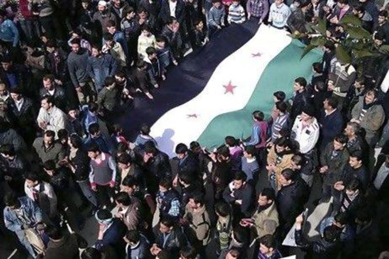 Anti-Syrian regime protesters on Friday carry a large Syrian revolution flag during a demonstration in Damascus.