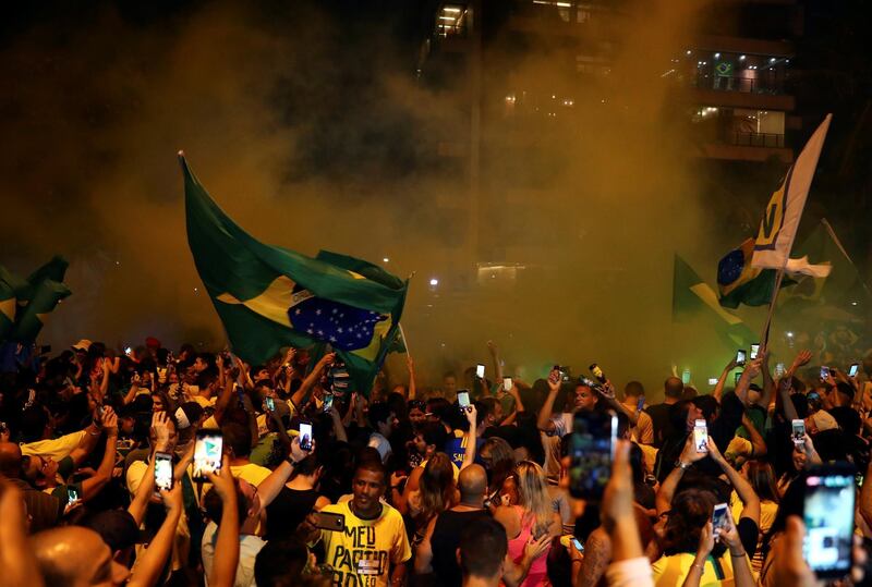 Supporters in Rio de Janeiro of the far-right lawmaker and presidential candidate of the Social Liberal Party (PSL) react after Mr Bolsonaro's victory. REUTERS