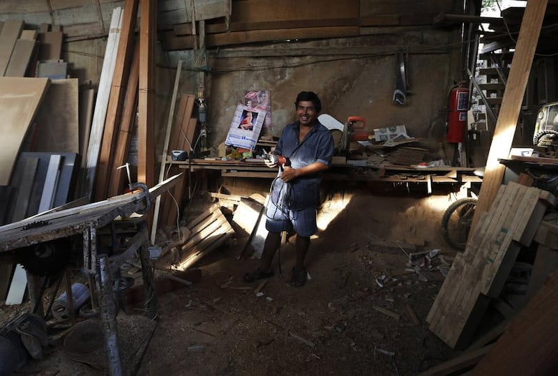 Carpenter Antonio Abad poses in his workshop in Gosen City. Abad arrived in Gosen City in 1995 when it was just a settlement, and helped his neighbours build their homes. He now has a factory that manufactures windows, doors and furniture. Mariana Bazo / Reuters