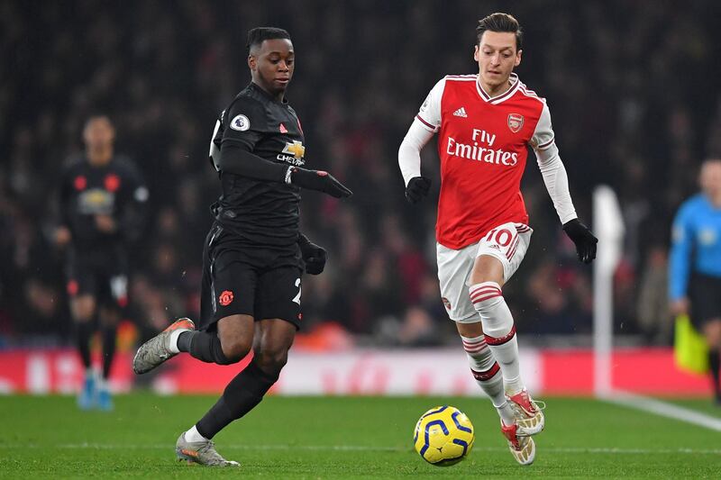 Manchester United's English defender Aaron Wan-Bissaka (L) vies with Arsenal's German midfielder Mesut Ozil (R) during the English Premier League football match between Arsenal and Manchester United at the Emirates Stadium in London on January 1, 2020. (Photo by Ben STANSALL / AFP) / RESTRICTED TO EDITORIAL USE. No use with unauthorized audio, video, data, fixture lists, club/league logos or 'live' services. Online in-match use limited to 120 images. An additional 40 images may be used in extra time. No video emulation. Social media in-match use limited to 120 images. An additional 40 images may be used in extra time. No use in betting publications, games or single club/league/player publications. / 