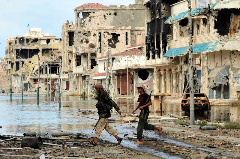 Anti-Gaddafi fighters walk at an area where clashes with Gaddafi forces took place in Sirte October 19, 2011. REUTERS/Esam Al-Fetori (LIBYA - Tags: POLITICS CONFLICT) *** Local Caption ***  EF03_LIBYA-_1019_11.JPG