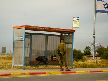 SOUTHERN ISAEL  - MARCH 21: An IDF soldier waits for bus on March 21, 2024 in southern Israel. On February 22, the IDF concluded that it was safe for residents in communities located more than 4 kilometers from the Gaza border could return. Residents responded to the government's position by countering that residents of neighboring kibbutz Sufa, less than a kilometer away, have not been advised to go back. Though some residents are eager to return, they are also concerned that until the IDF and Israeli government discuss a plan to invade Rafah, approximately 13 km away, it is not yet safe. IDF bombardments can still be heard and seen from the edges of the Kibbutz.  (Photo by Alexi J. Rosenfeld/Getty Images)