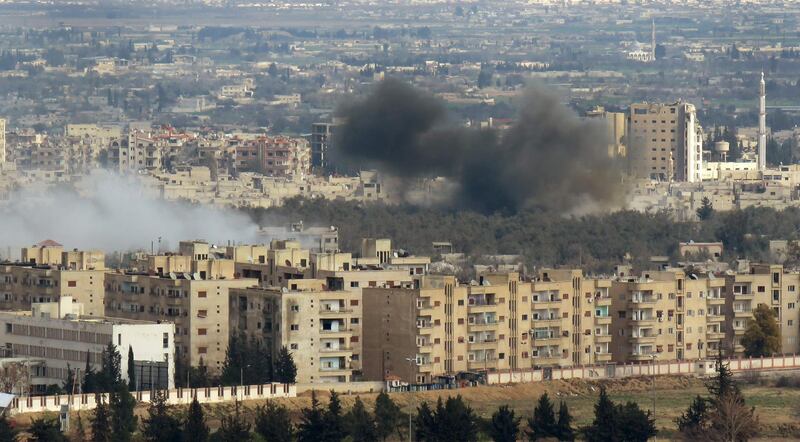 A picture taken from a government-controlled area on the outskirts of Harasta on the northeastern suburbs of Damascus on February 28, 2018, shows smoke rising from areas targeted by Syrian army shelling in the towns of Douma and Harasta. AFP