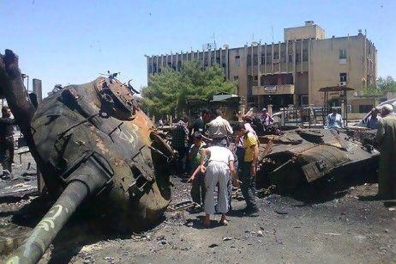 Anti-Syrian regime citizens look at Syrian tank that was damaged during clashes between rebels and Syrian government forces, in Ariha in Idlib province. Rebel fighters killed at least 80 government soldiers at the weekend, according to the opposition Syrian Observatory for Human Rights.