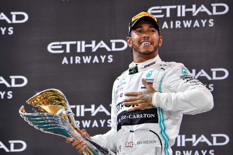 TOPSHOT - Mercedes' British driver Lewis Hamilton celebrates his win at the Yas Marina Circuit in Abu Dhabi, after the final race of the Formula One Grand Prix season, on December 1, 2019.  / AFP / GIUSEPPE CACACE
