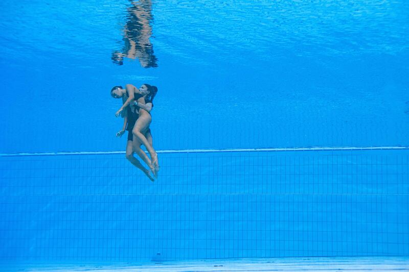 Anita Alvarez is helped from the pool after fainting at the World Aquatics Championships. AFP