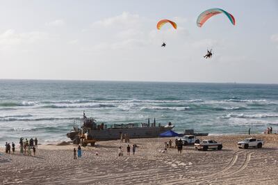 Paragliders pass above US troops working around the vessels. Reuters