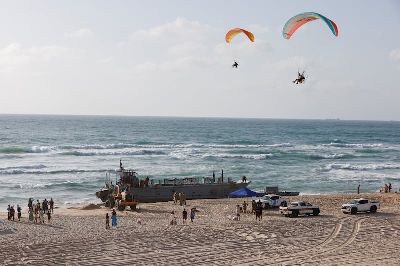 Paragliders soar above US troops working with vessels used for delivering aid to Palestinians via a floating pier in Gaza, after ships ran aground in Ashdod, Israel. Reuters