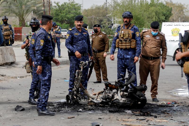 FILE PHOTO: Members of security forces inspect the scene of an explosion in Baghdad, Iraq March 23, 2021. REUTERS/Khalid al-Mousily/File Photo