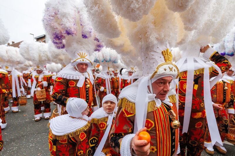 Participants wear hats with plumes of ostrich feathers during a carnival parade in Binche, Belgium. EPA