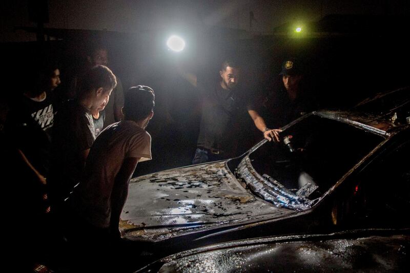 People check damage on burned vehicles following a fire that broke out in the Shuqair-Mostorod crude oil pipeline, on the Cairo-Ismailia road, in Egypt. A ruptured crude oil pipeline set off a monstrous blaze on a desert highway in Egypt on Tuesday, injuring at least 17 people, local authorities said. AP Photo