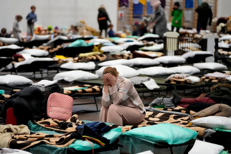 A woman puts her head in her hands as she sits on a cot in a shelter, set up for displaced persons fleeing Ukraine, inside a school gymnasium in Przemysl, Poland. AP Photo