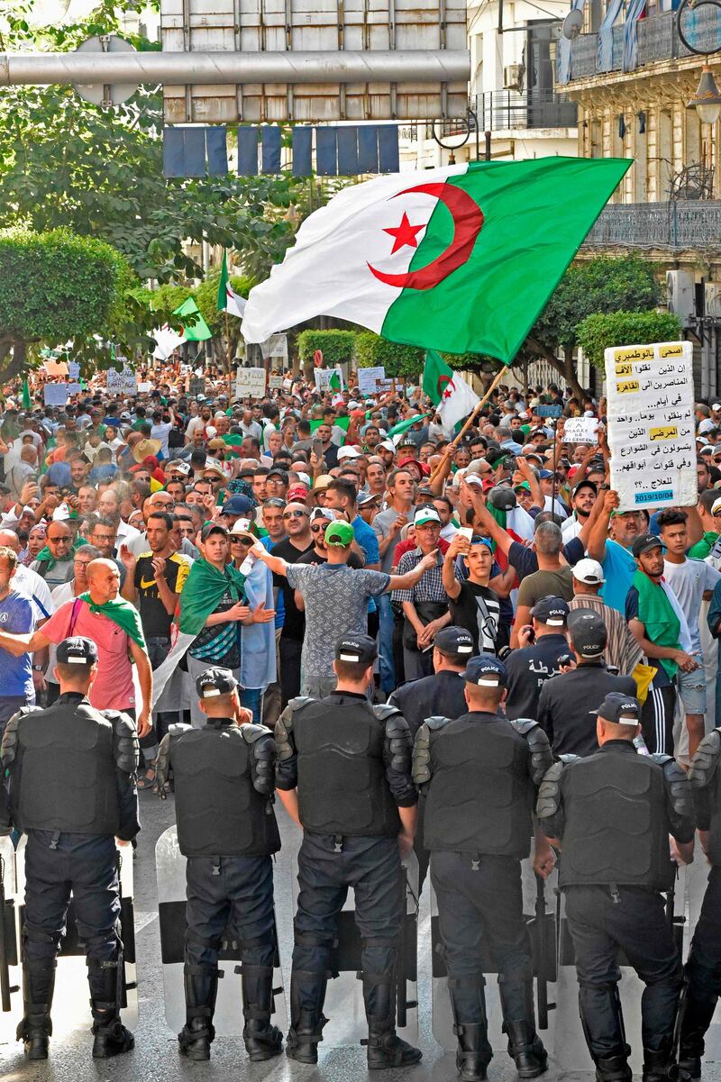 Algerian protesters face riot police during a demonstration against the ruling class in the capital Algiers on October 4, 2019, for the 33rd consecutive Friday since the movement began.  / AFP / RYAD KRAMDI                        
